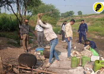 हातभट्टी दारू निर्मितीच्या ठिकाणी कारवाई करताना पोलीस अधिकारी